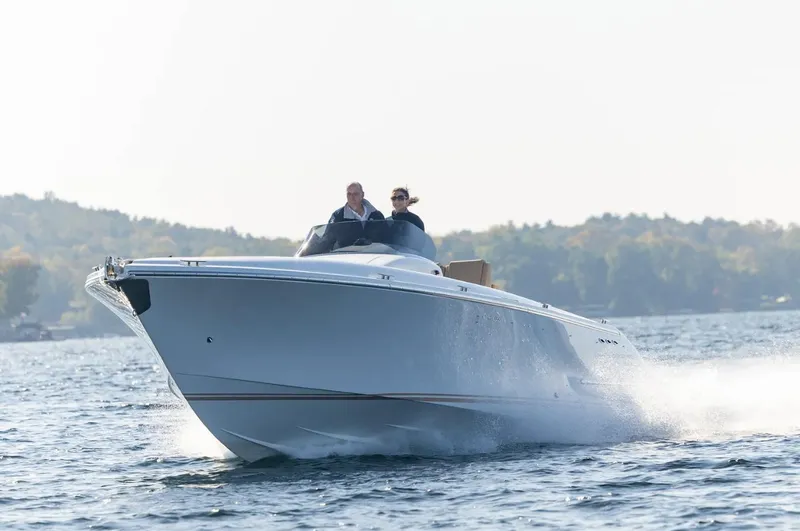 Slide: The Image of 2022 Comitti Isola I-33 speedboat cruising on a lake with two passengers. - 3