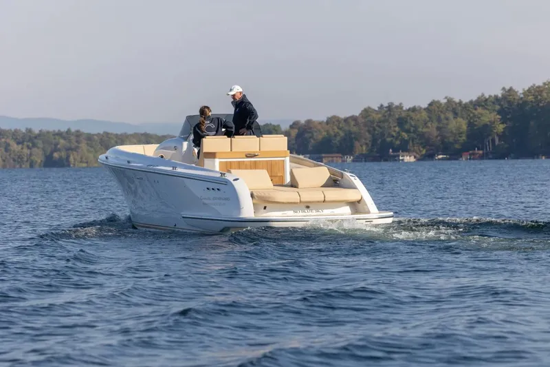 Slide: The Image of 2022 Comitti Isola I-33 boat cruising on a serene lake with two passengers. - 4