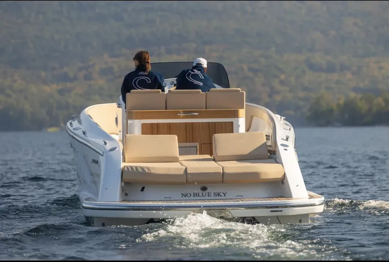 Slide: The Image of 2022 Comitti Isola I-33 boat cruising on a lake with two passengers onboard. - 5