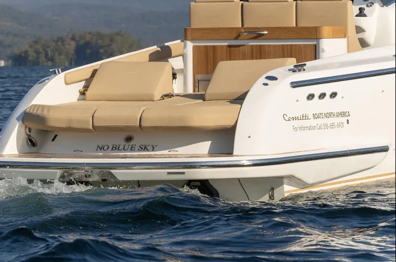 Slide: The Image of 2022 Comitti Isola I-33 luxury boat with beige seating on a serene lake. - 6