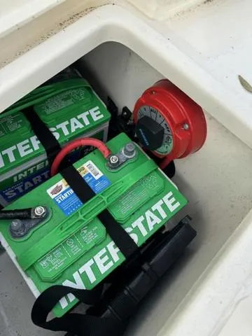 Slide: The Image of 2023 Bulls Bay 200CC boat battery compartment with Interstate batteries and red power switch. - 18