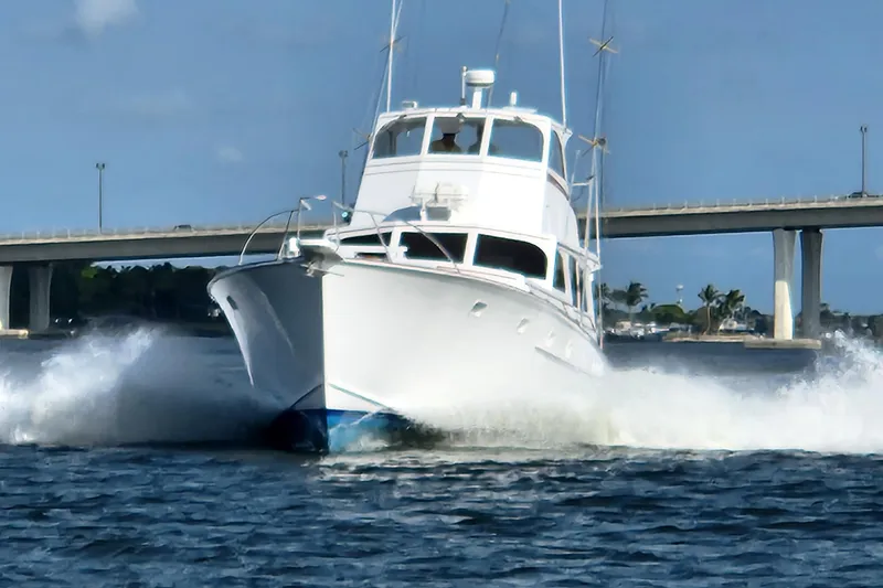 Slide: The Image of 1971 Whiticar Sportfish boat cruising on water near a bridge under clear skies. - 2