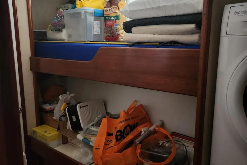 Slide: The Image of 1971 Whiticar Sportfish interior storage with shelves, bags, and household items. - 20