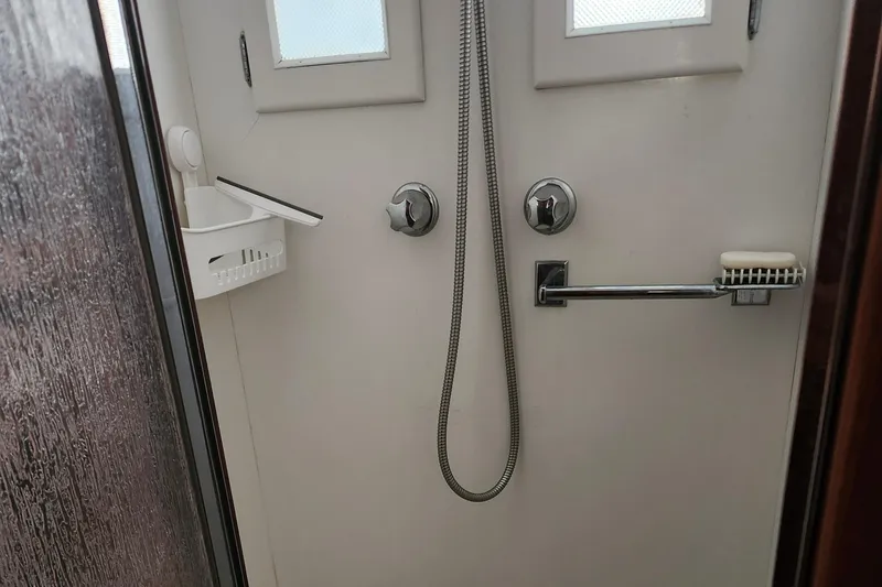 Slide: The Image of Shower area in a 1971 Whiticar Sportfish boat, featuring dual knobs and a handheld showerhead. - 22