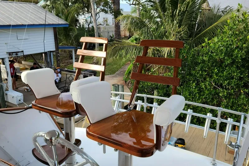 Slide: The Image of 1971 Whiticar Sportfish boat with polished wooden chairs and lush greenery in the background. - 28