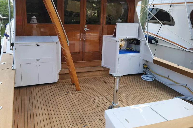 Slide: The Image of 1971 Whiticar Sportfish boat deck with wooden flooring and white storage units. - 31