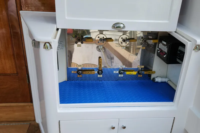 Slide: The Image of 1971 Whiticar Sportfish control panel with valves and switches in a white cabinet. - 33