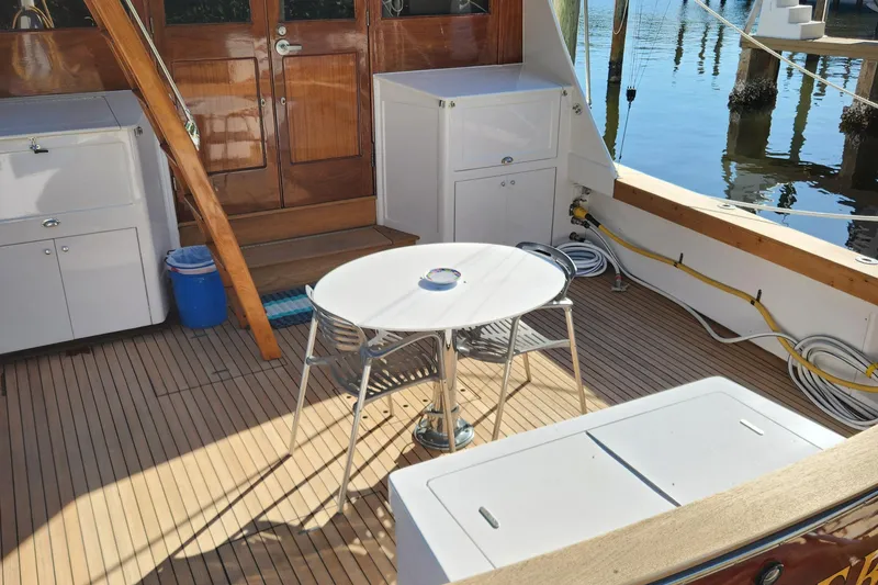 Slide: The Image of 1971 Whiticar Sportfish boat deck with wooden flooring and white furniture. - 35