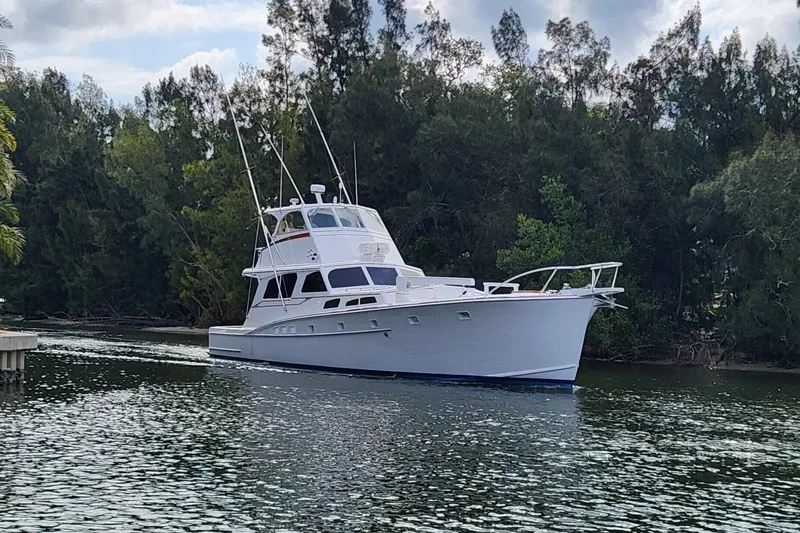 Slide: The Image of 1971 Whiticar Sportfish boat cruising on a calm river, surrounded by lush trees. - 4