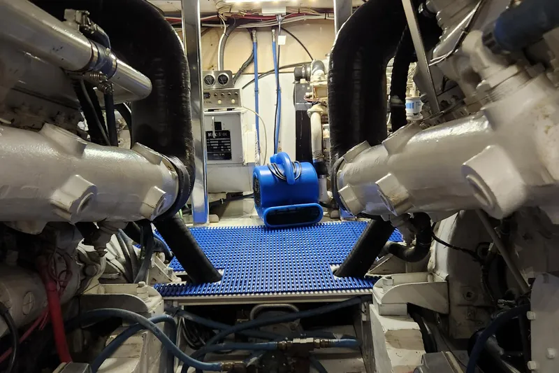 Slide: The Image of Engine room of a 1971 Whiticar Sportfish boat, featuring dual engines and blue flooring. - 42