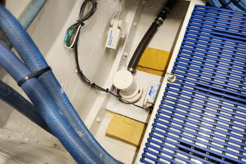 Slide: The Image of 1971 Whiticar Sportfish engine room with blue hoses and wiring. - 49