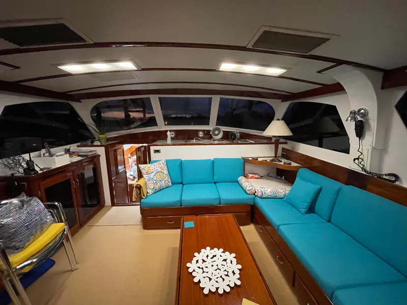Slide: The Image of 1971 Whiticar Sportfish interior with blue seating, wooden accents, and modern lighting. - 7
