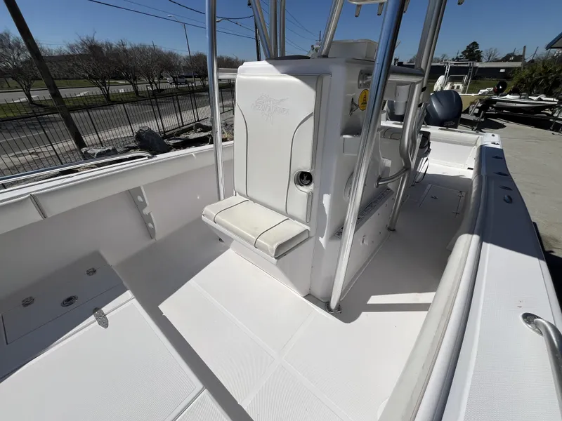 Slide: The Image of 2010 Ocean Runner 29 cc boat interior with seating and console, docked outdoors. - 20
