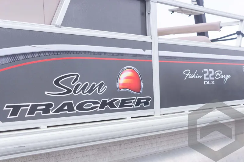 Slide: The Image of 2015 Sun Tracker Fishin' Barge 22 DLX boat side view with logo and branding. - 12