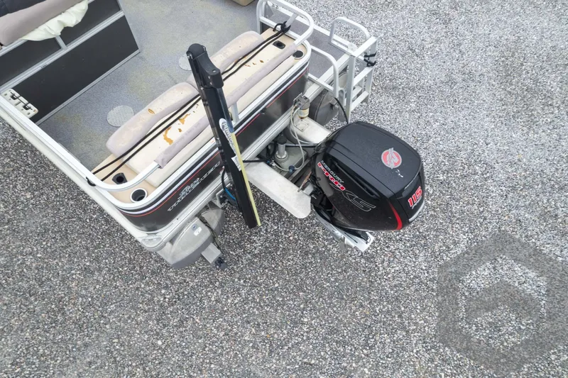 Slide: The Image of 2015 Sun Tracker Fishin' Barge 22 DLX with outboard motor on gravel surface. - 33