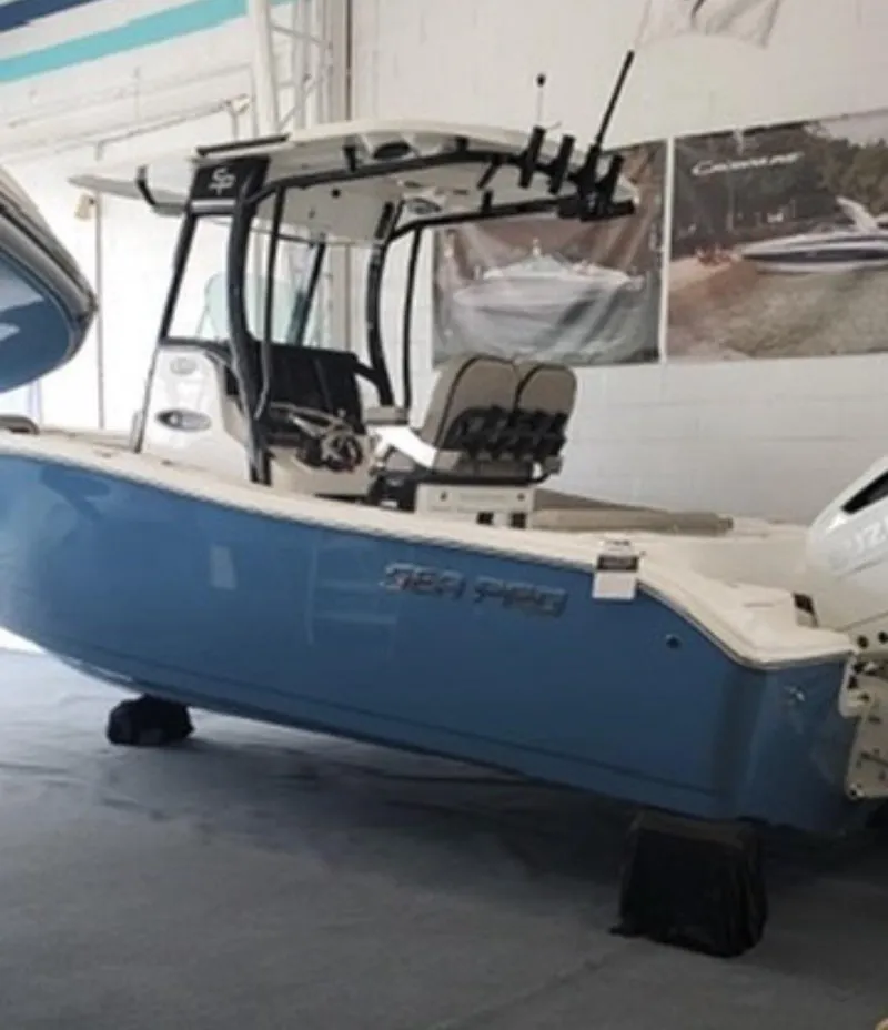 Slide: The Image of 2022 Sea Pro 239 Center Console boat displayed indoors, featuring a sleek blue hull. - 2