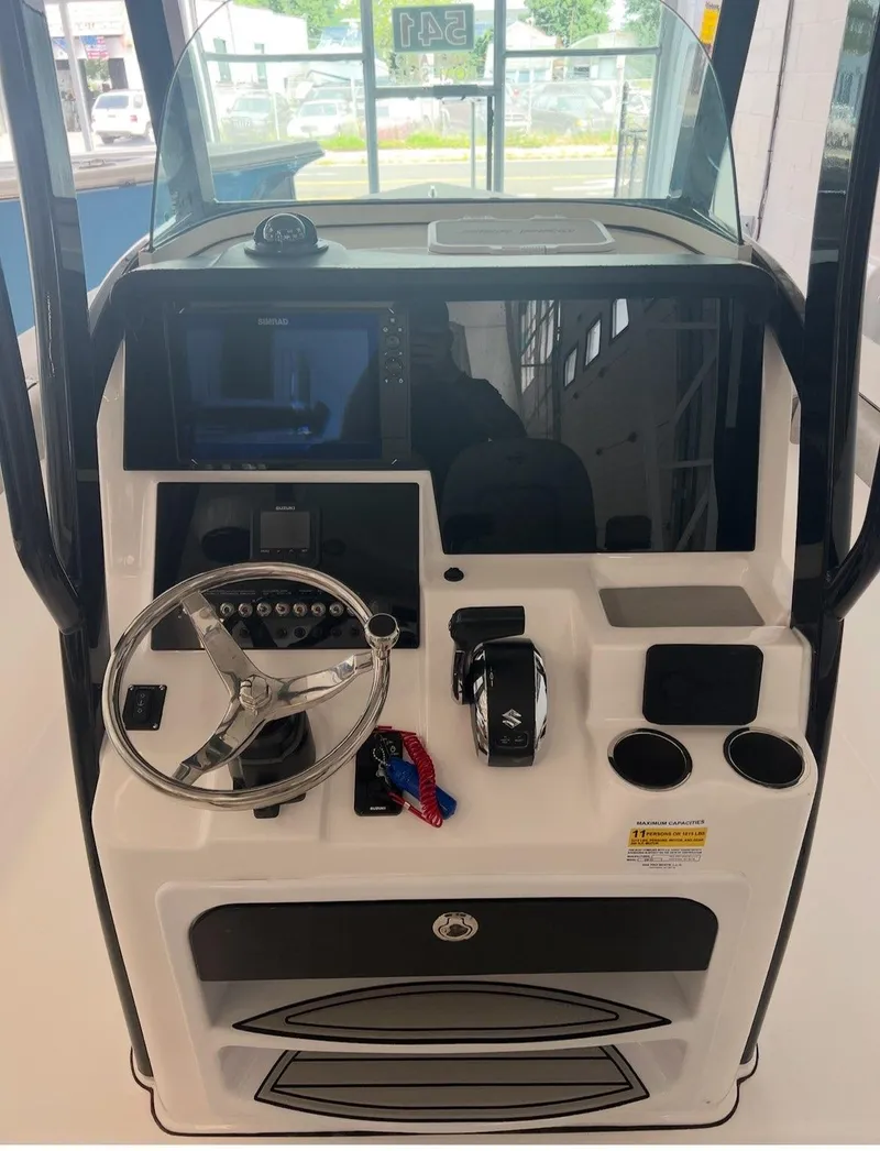 Slide: The Image of 2022 Sea Pro 239 Center Console boat dashboard with steering wheel and controls. - 4