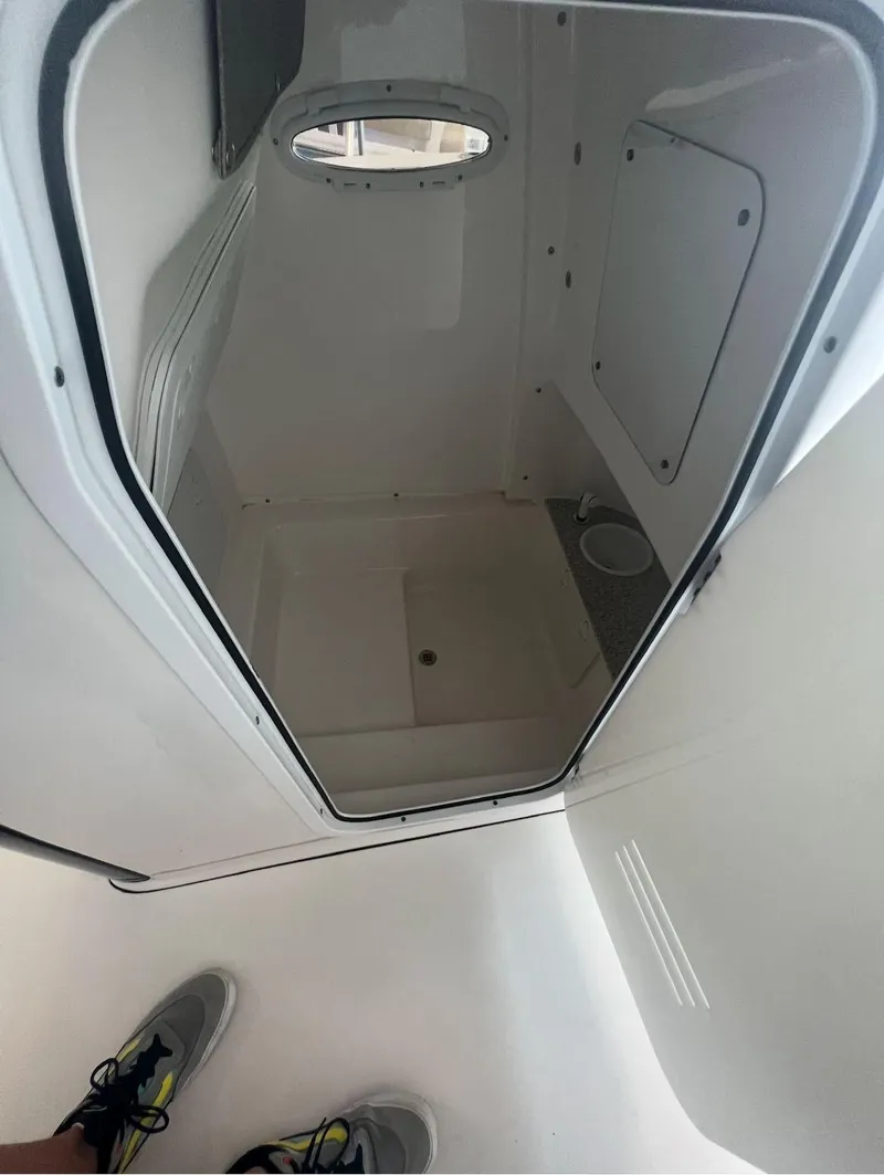 Slide: The Image of 2022 Sea Pro 239 Center Console interior compartment with clean, white finish. - 9