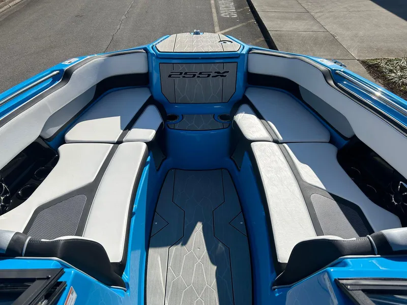 Slide: The Image of 2023 Yamaha Boats 255XD interior with blue and white seating, showcasing spacious design. - 11