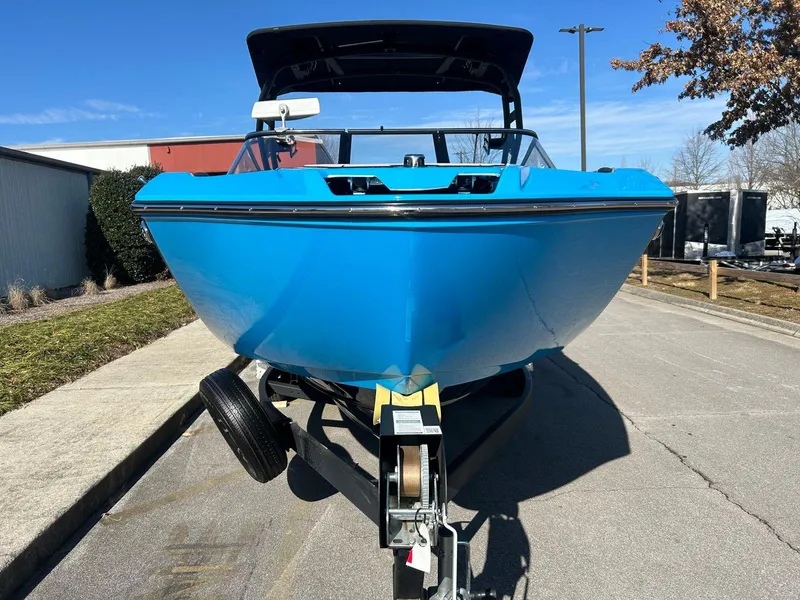 Slide: The Image of 2023 Yamaha Boats 255XD in vibrant blue on a trailer, parked outdoors. - 4