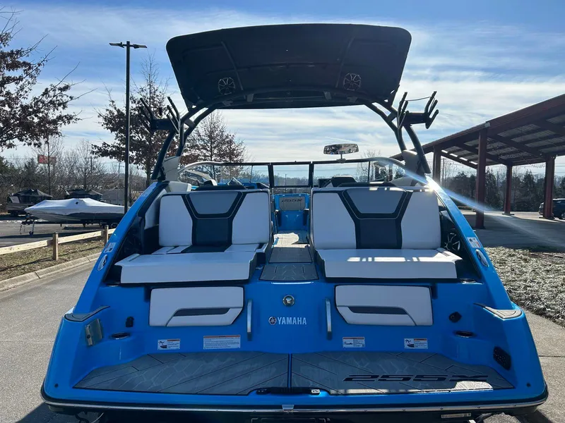 Slide: The Image of 2023 Yamaha Boats 255XD, blue exterior, rear view with seating and canopy. - 5