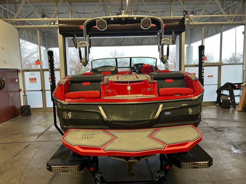 Slide: The Image of 2020 MasterCraft X22 boat with red and black interior in a showroom. - 10