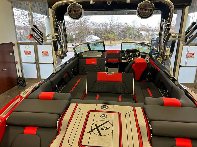 Slide: The Image of 2020 MasterCraft X22 boat interior with red and black seating, advanced sound system. - 12