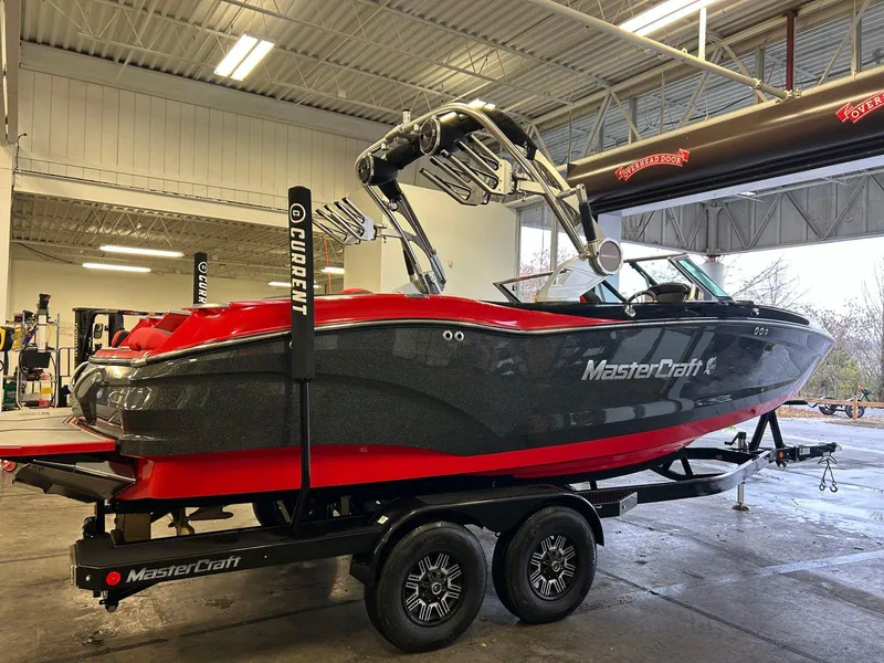 Slide: The Image of 2020 MasterCraft X22 boat in a garage, featuring a sleek red and gray design. - 3