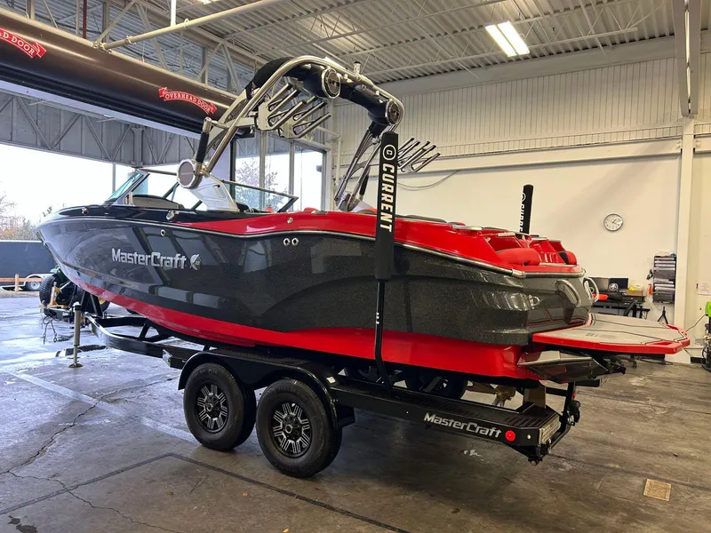 Slide: The Image of 2020 MasterCraft X22 boat in a garage, featuring a sleek black and red design. - 4
