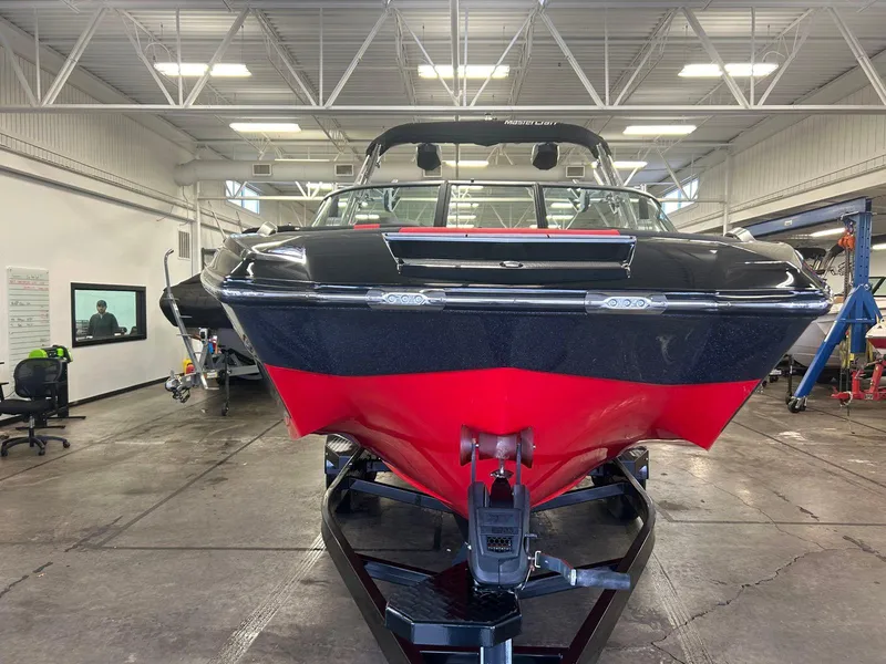 Slide: The Image of 2020 MasterCraft X22 boat in a garage, front view, red and black design. - 6