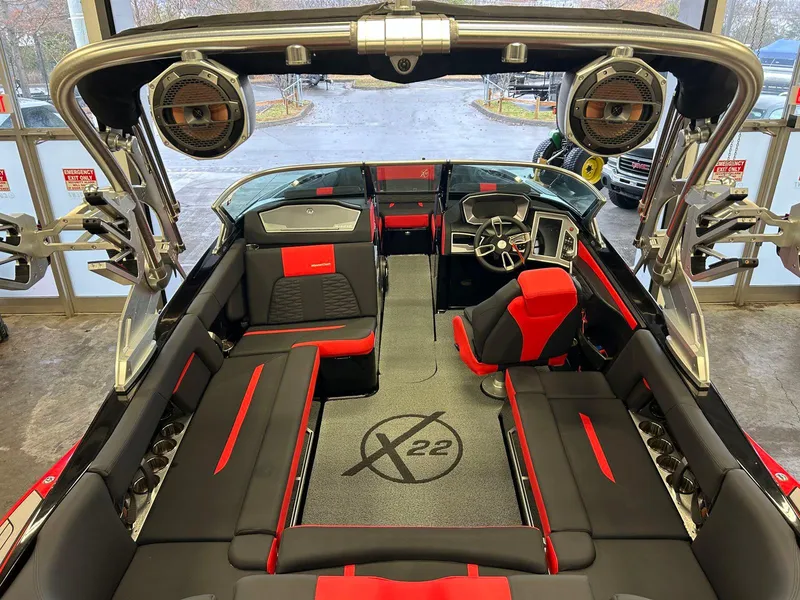 Slide: The Image of 2020 MasterCraft X22 boat interior with red and black seating, advanced dashboard, and premium sound system. - 8