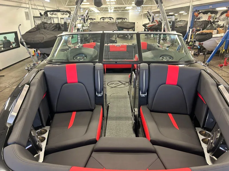 Slide: The Image of 2020 MasterCraft X22 boat interior with black and red seating in a showroom. - 9
