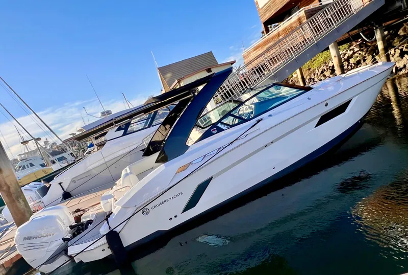 Slide: The Image of 2020 Cruisers Yachts 338OB docked, sleek design, white exterior, sunny day. - 3