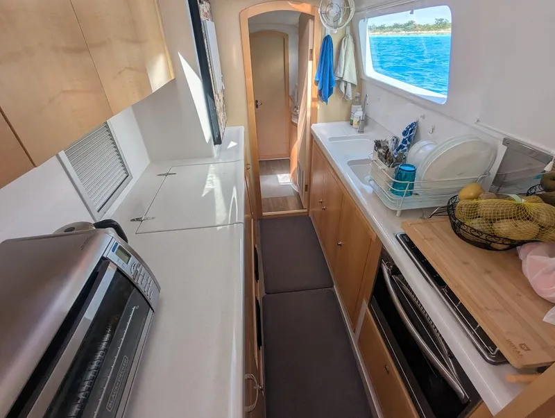 Slide: The Image of Interior of 2020 Seawind 1260 catamaran kitchen with ocean view through window. - 20