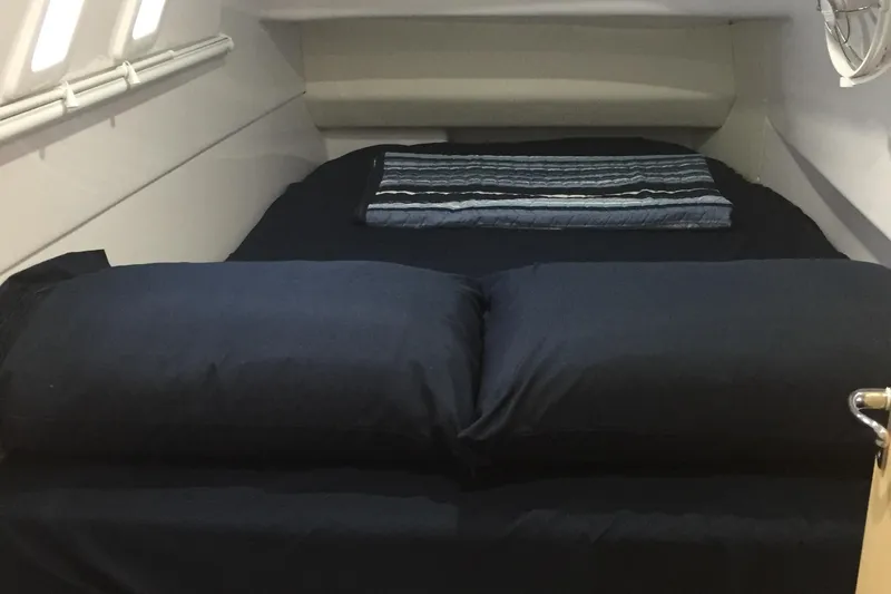 Slide: The Image of 2020 Seawind 1260 cabin interior with a neatly made bed and striped blanket. - 26