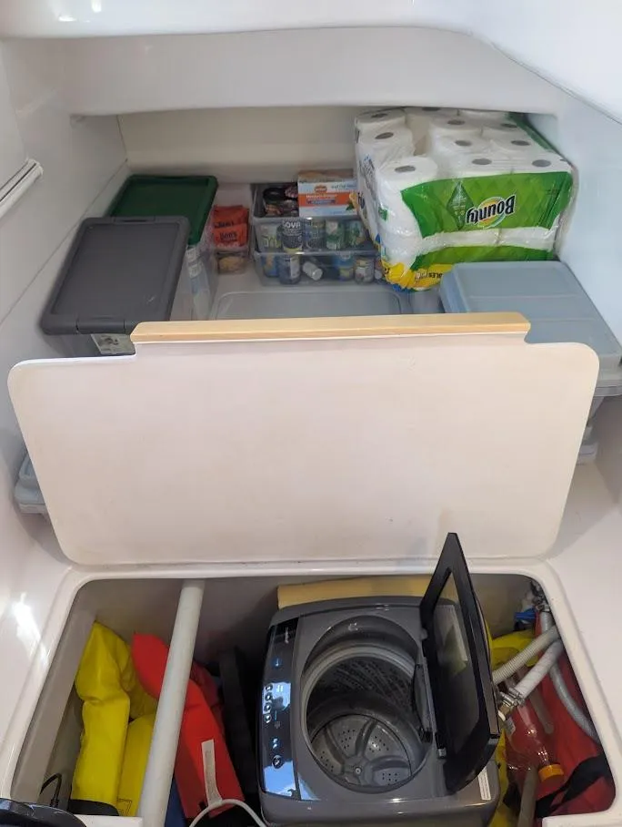 Slide: The Image of Storage area in a 2020 Seawind 1260 yacht with supplies and a compact washing machine. - 27