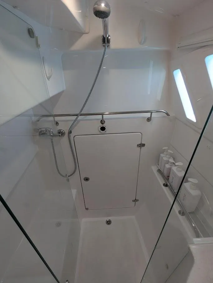 Slide: The Image of 2020 Seawind 1260 yacht shower with modern fixtures and storage shelves. - 28