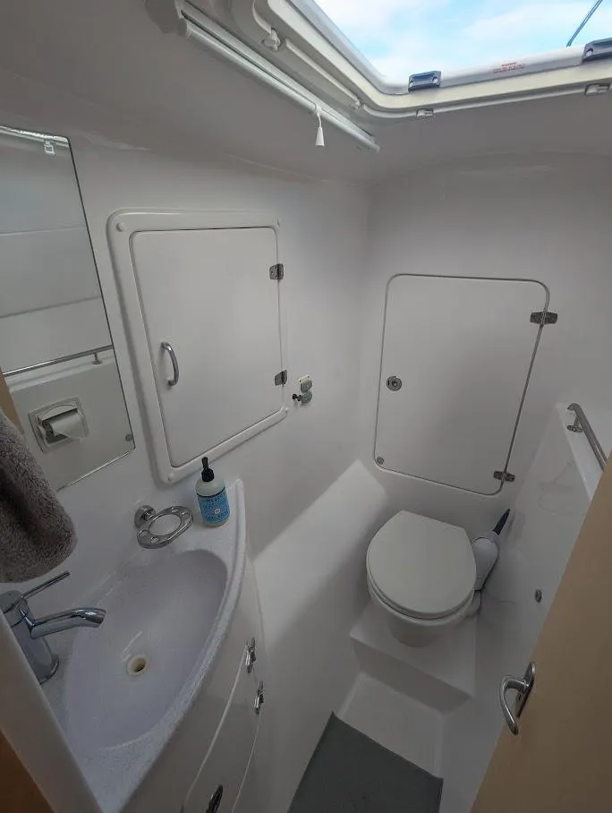 Slide: The Image of 2020 Seawind 1260 yacht bathroom with sink, toilet, and storage compartments. - 29