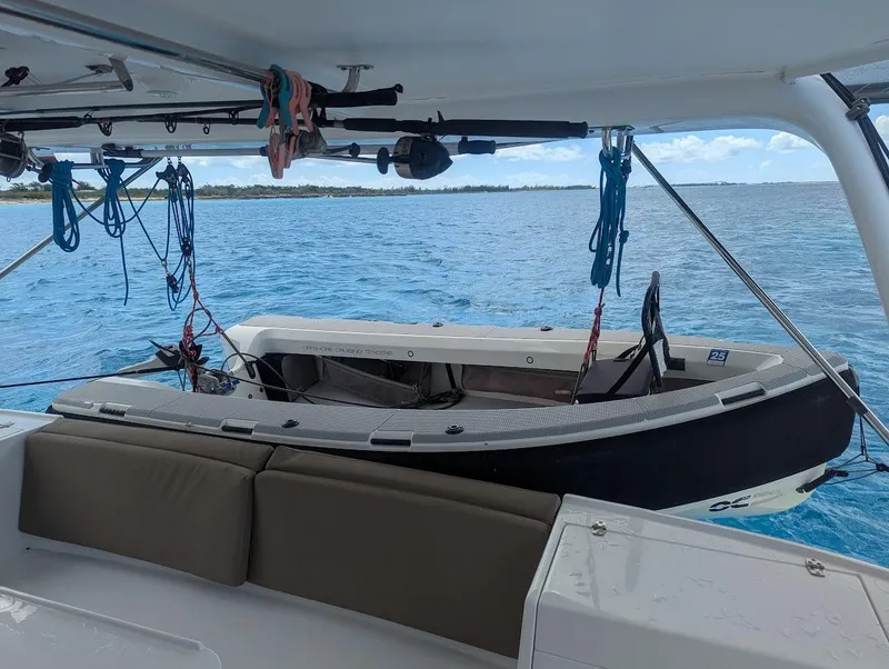 Slide: The Image of Seawind 1260 catamaran interior with dinghy, 2020 model, anchored in clear blue waters. - 7