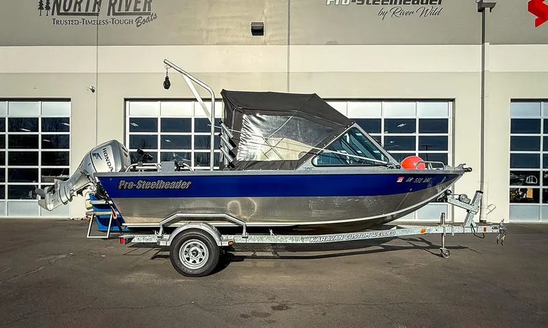 Slide: The Image of 2011 Pro-Steelheader 18 Sea Predator OS boat on trailer, parked outside dealership. - 23