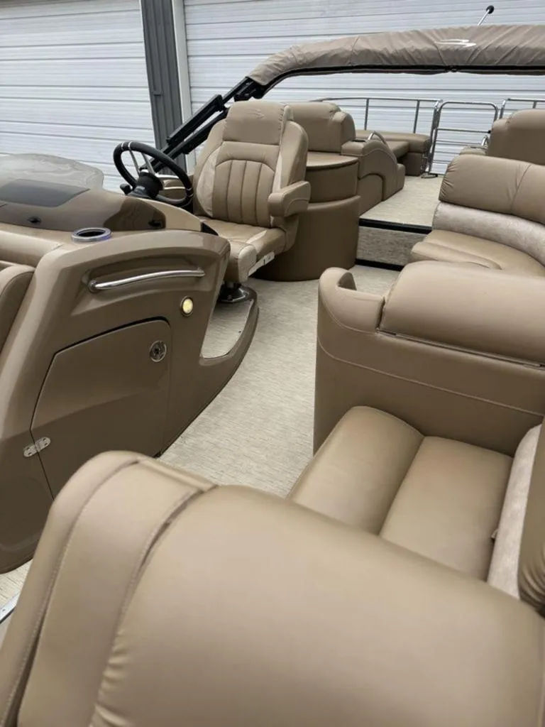 Slide: The Image of 2016 Bennington 2575 QCW I/O boat interior with tan leather seating and steering wheel. - 10
