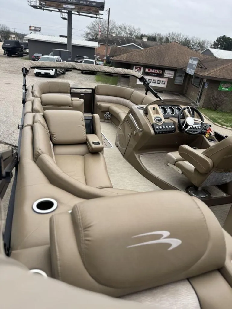 Slide: The Image of 2016 Bennington 2575 QCW I/O boat interior with beige seating and modern dashboard. - 13