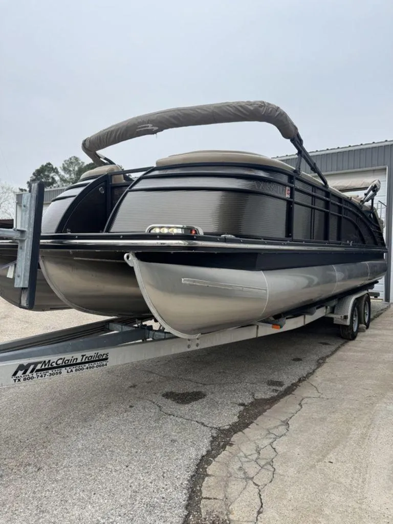 Slide: The Image of 2016 Bennington 2575 QCW I/O pontoon boat on trailer, parked outdoors. - 15