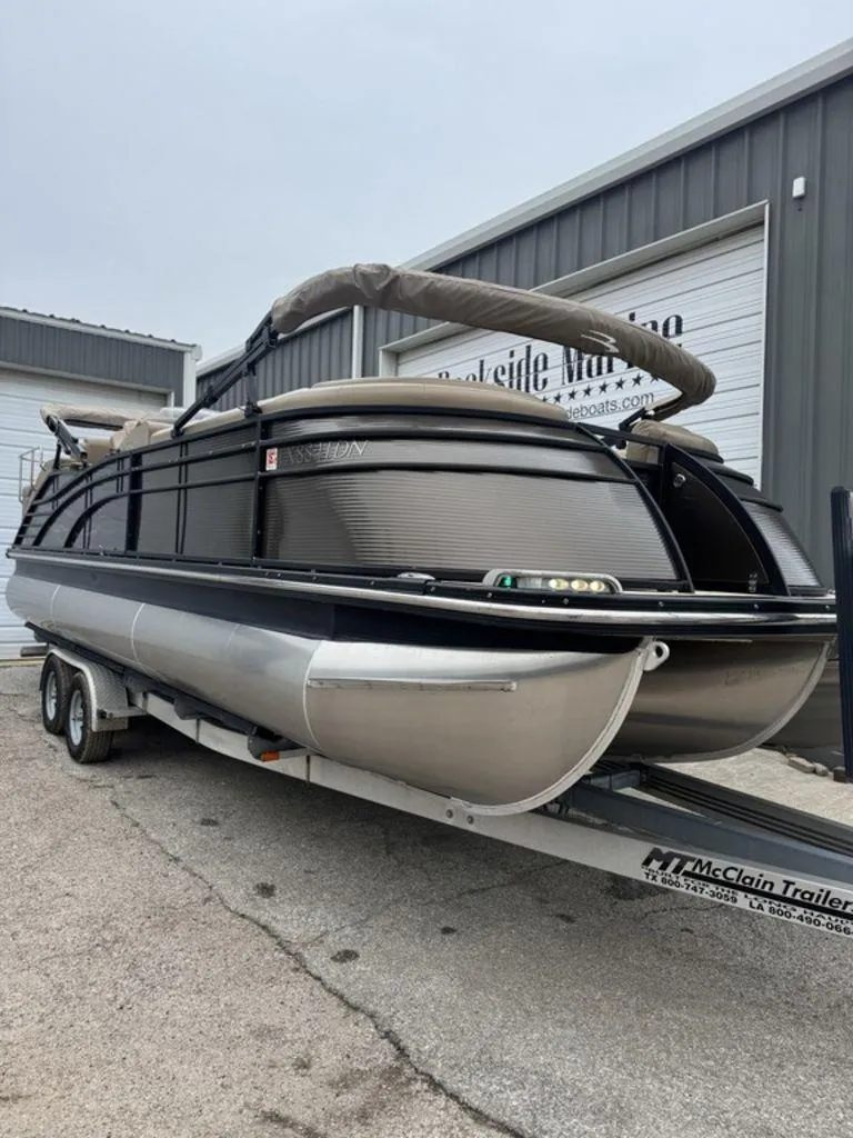 Slide: The Image of 2016 Bennington 2575 QCW I/O pontoon boat on trailer at dealership. - 16