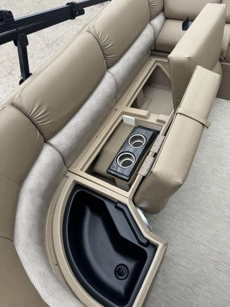 Slide: The Image of 2016 Bennington 2575 QCW I/O boat interior with beige seating and built-in cup holders. - 20