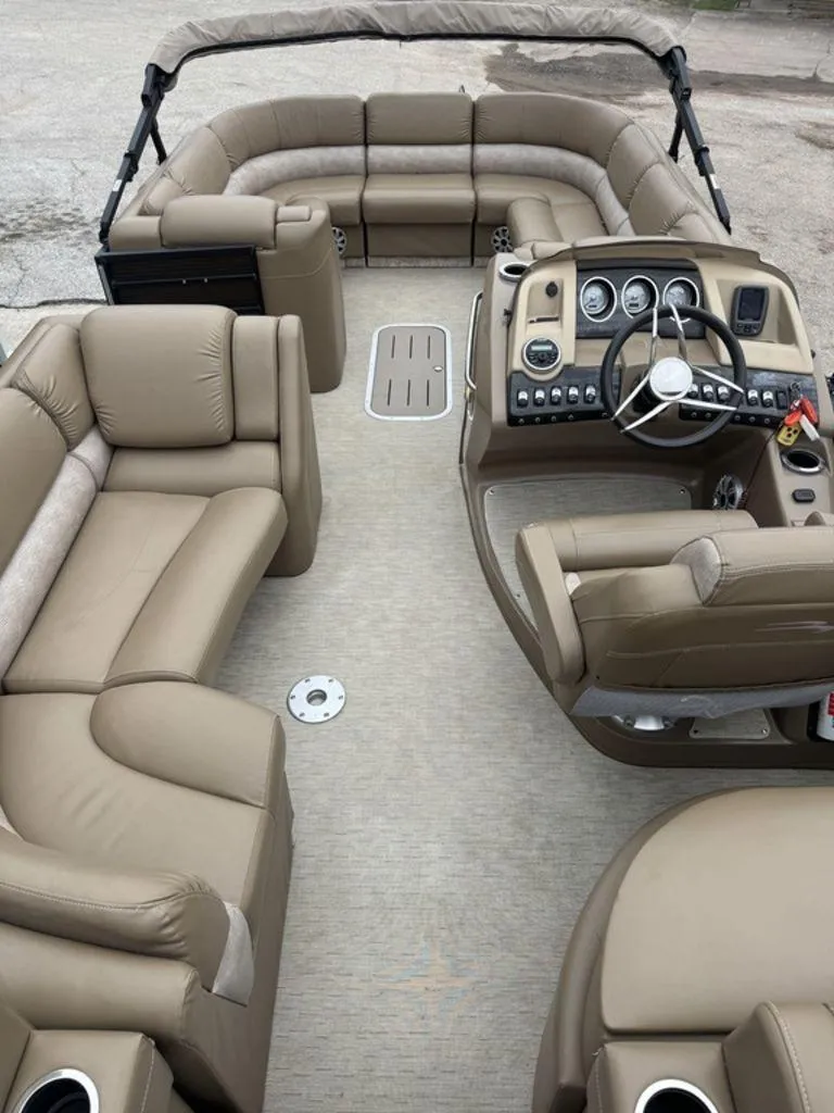 Slide: The Image of 2016 Bennington 2575 QCW I/O pontoon boat interior with beige seating and steering console. - 22