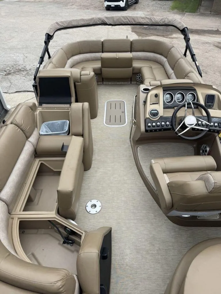Slide: The Image of 2016 Bennington 2575 QCW I/O boat interior with beige seating and modern dashboard. - 24