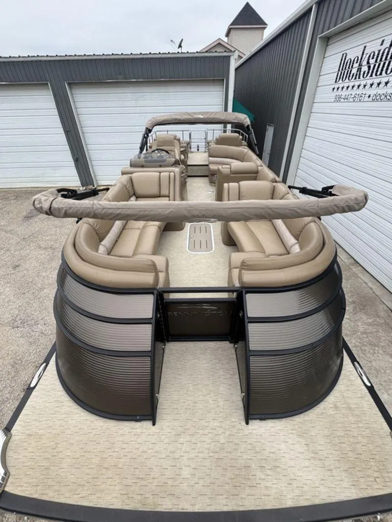 Slide: The Image of 2016 Bennington 2575 QCW I/O pontoon boat with beige seating, dockside view. - 3