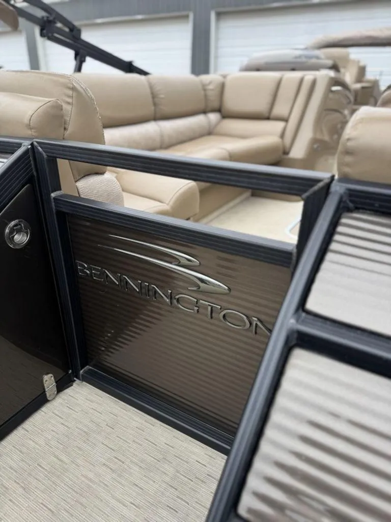 Slide: The Image of 2016 Bennington 2575 QCW I/O boat interior with beige seating and branded panel. - 4