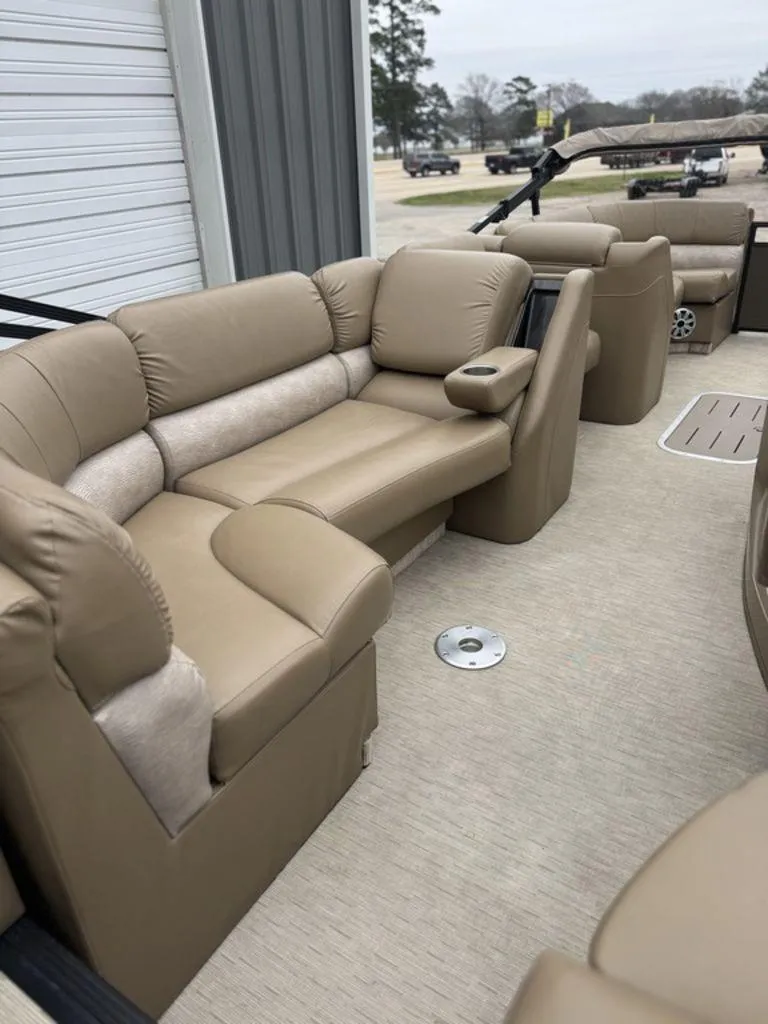 Slide: The Image of 2016 Bennington 2575 QCW I/O boat interior with beige seating and armrests. - 7